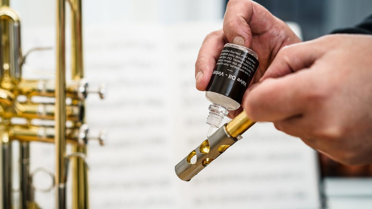 Applying trumpet valve oil to piston during maintenance