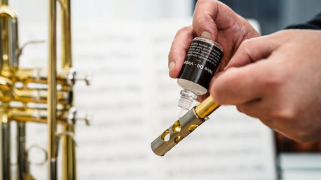 Applying trumpet valve oil to piston during maintenance