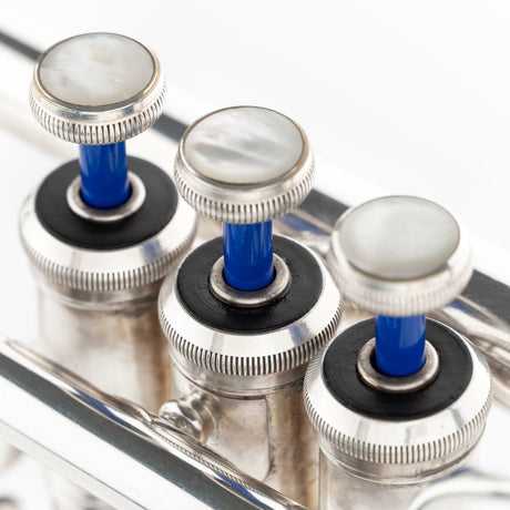Detail shot of one KGUmusic brass Blue Lacquer valve stem on a trumpet.