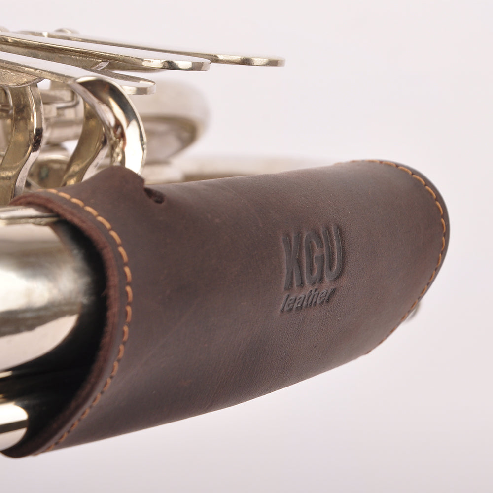 Leather hand guard on French horn in brown color on white background.