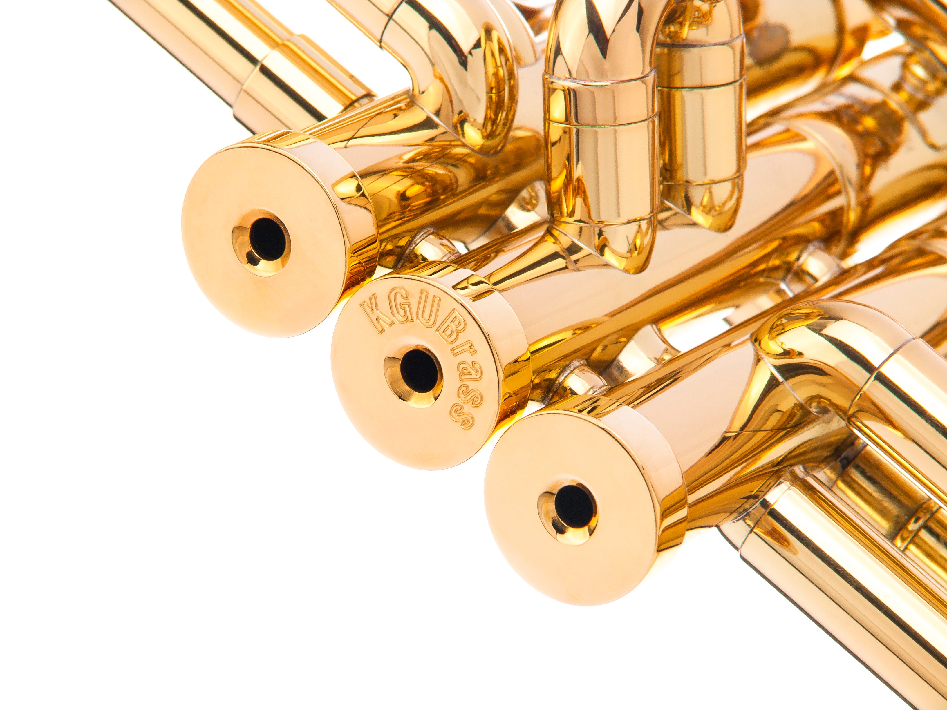 Three solid brass golden plated trumpet valve caps on a trumpet.